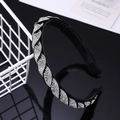 Detail of a black twisted headband with sparkling rhinestones on a reflective surface - White Zircon