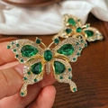 Dettaglio della spilla a farfalla dorata con pietre verdi e cristalli trasparenti - Farfalla di Strass Verdi