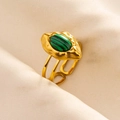 Detail of adjustable gold-plated ring with oval green malachite stone on textured fabric - Gold-Green