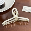 Elegant cream white rhinestone hair claw clip with twisted ribbon design on wood surface - 11.3cm / Cream