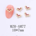 Macro detail of V-shaped gold nail art charm with pink rhinestones and white pearls - Gold Base Pink Rhinestone Style (AM77)