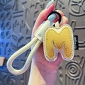 Letter M keychain made of yellow and white leather with a matching strap and metal ring - Letter M