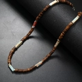Detail of coconut shell beaded necklace with natural stone accents on dark surface - Blue Pattern Stone