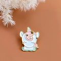 Lindo broche esmaltado de unicornio blanco y rosa con borde dorado sobre fondo marrón suave - Dorado
