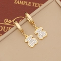 Golden bear dangle earrings with sparkling rhinestones on a textured brown background - Bear Style / Gold