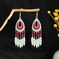 Bohemian silver earrings with red beads and feather charms on a dark background - Red