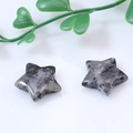 Pair of polished grey natural gemstone star ornaments on a clean white surface - Flash Stone (Labradorite)
