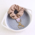 Detalle de coletero de terciopelo beige con pedrería y llavero en cesta tejida - café