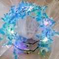 Detail of blue floral LED headpiece with warm lights and white bridal veil accessory - Blue