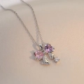 Close-up of sparkling pink heart-shaped zircon bow pendant on a silver steel chain - Silver-Pink Zircon