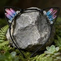 Macro shot of cat ear headband with pink and blue crystals on natural mossy stones - Red & Blue Cat Ears