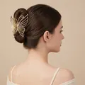 Elegant gold butterfly metal hair claw clip displayed on a woman's bun hairstyle - Hollow Butterfly Shape / Medium / Gold