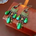 Retro-Ohrringe aus Bronze mit grünen Blumenanhängern auf brauner Lederbox - Ohrhaken-Stil / Bronze-Grün