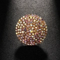 Elegant gold round brooch with sparkling rainbow rhinestones on a textured black surface - Gold
