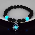 Dettaglio del bracciale loto luminoso con perle di lava nera che brillano al buio - 8mm Pietra Lavica Naturale con Luce Blu