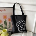 Close-up of black Oxford tote bag with white cat art print and decorative background - Black with Wow Cat