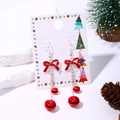 Christmas earrings featuring red bows and silver bells on a festive background - Red Bell