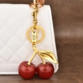 Llavero de cereza roja brillante con hoja dorada y colgante de letra B en bolso blanco - Letra B
