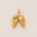 Macro detail of a 18K gold plated pinky swear gesture pendant with a smooth polished finish - Hands