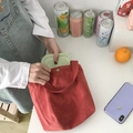 Borsa termica in velluto a coste rosso con portapranzo verde in scena lifestyle - Piccolo / Rosso