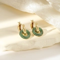 Détail de créoles en or 18 carats avec cristaux de zircon vert sur un socle en pierre - Zircon Vert