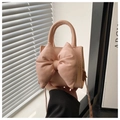 Close-up of pink PU leather handbag with a large bow detail and elegant texture - Pink