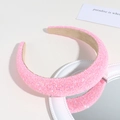 Detail view of a pink glitter sponge headband on a mirror with sparkling sequins textures - Dense Sequin Style / Sequined Pink