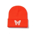Close-up of vibrant orange knit beanie featuring detailed white butterfly embroidery - One Size / Orange Red