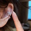 Close-up of a sparkling zircon butterfly ear cuff with a star dangle worn on an ear. - Butterfly Star Style (Single Piece) / Silver