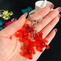 Close-up of translucent red resin gummy bear charms on a silver-tone keychain - Red