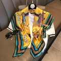 Detail of yellow silk scarf with geometric horse patterns draped on a white top - Yellow Pony