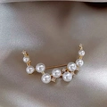 Close-up of elegant gold brooch featuring white pearls and sparkling crystals on silk - 424# Pearl Smile