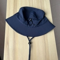 Detail view of navy blue bucket hat featuring adjustable drawstring and windproof chin cord - One Size / Navy Blue