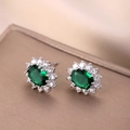 Dettaglio di orecchini a lobo ovali con zircone verde e cornice di strass scintillanti - Verde