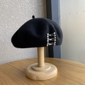 Classic black wool beret with three silver metal pins decoration on a wooden stand - M (56-58cm) / Silver Buckle - Black