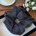Elegant large black organza mesh scrunchie with a glossy sheer finish on a display tray - Black