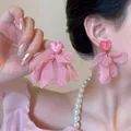 Detail of pink resin heart earrings with tiered chiffon flower petals and tassel design - Soft Pink Heart Fabric Petal Large Dangle Earrings