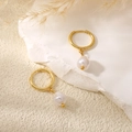 Detail of gold hoop earrings with baroque pearl drops on a white stone display stand - Round Gold Hoop Baroque Pearl Drop