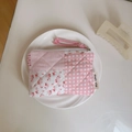 Detail of pink floral quilted pouch with zipper, hand strap and patchwork texture - Pink Grid Patchwork Floral
