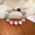 Detail of red and green gradient glass beads with golden metal spacers on a bracelet - Pink and Green Floral (Gold Plated)