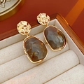 Detail of irregular gold metal earrings with brown marble stones on a linen box - Grey (Silver Pin)