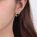 Minimalist gold heart stud earrings with black stone inlay shown on a model - Black