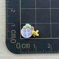 Detailed macro view of small 1.5cm resin pink window charm with bee on a scale mat - Pink Window