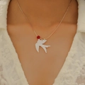 Gros plan du collier avec pendentif hirondelle blanche, perle rouge et chaîne dorée - Collier Oiseau (avec Perle Rouge X356) / Or KC