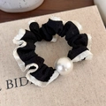 Close-up of black and white polka dot scrunchie with lace edge and white pearl detail - Black With White Edge
