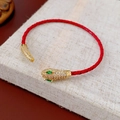 Close-up of woven red cord bracelet featuring a gold snake head with zircon embellishments - Leather Snake Head Bracelet Style (HB5012-14)