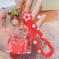 Detailed close-up of a castle-shaped liquid keychain with red sequins and star lanyard - Castle Red