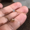 Dettaglio macro di orecchini a catenella in oro 18K con pietre di zircone rotonde - Oro