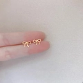 Elegant 925 silver bow stud earrings with a golden rope texture finish on fingertips - Hollow Bowknot / Gold