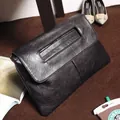 Detail view of black lychee grain PU leather envelope clutch with a cutout handle - Black